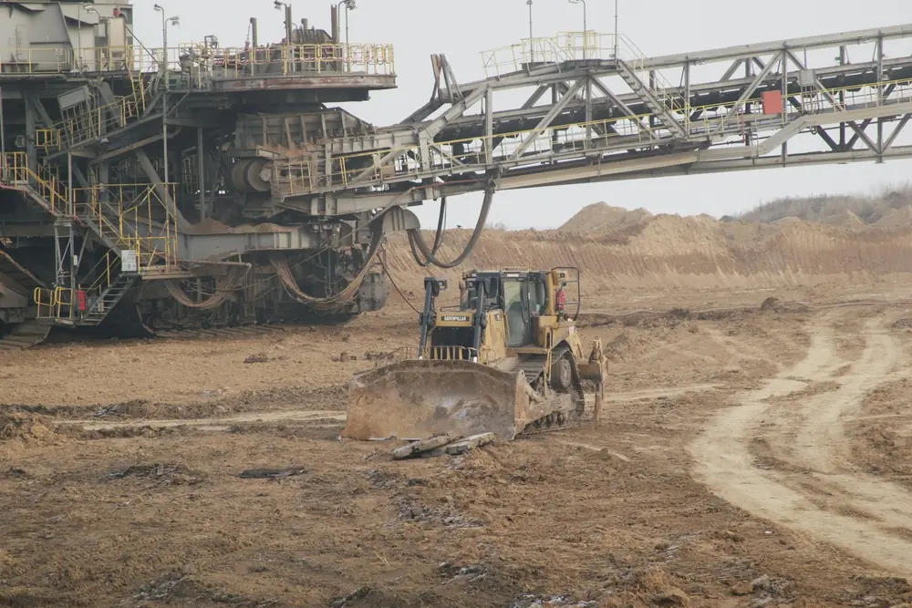 material being separated or stockpiled inside the fenced site; or utility/guardrail work in progress. Working light, mid-shift.